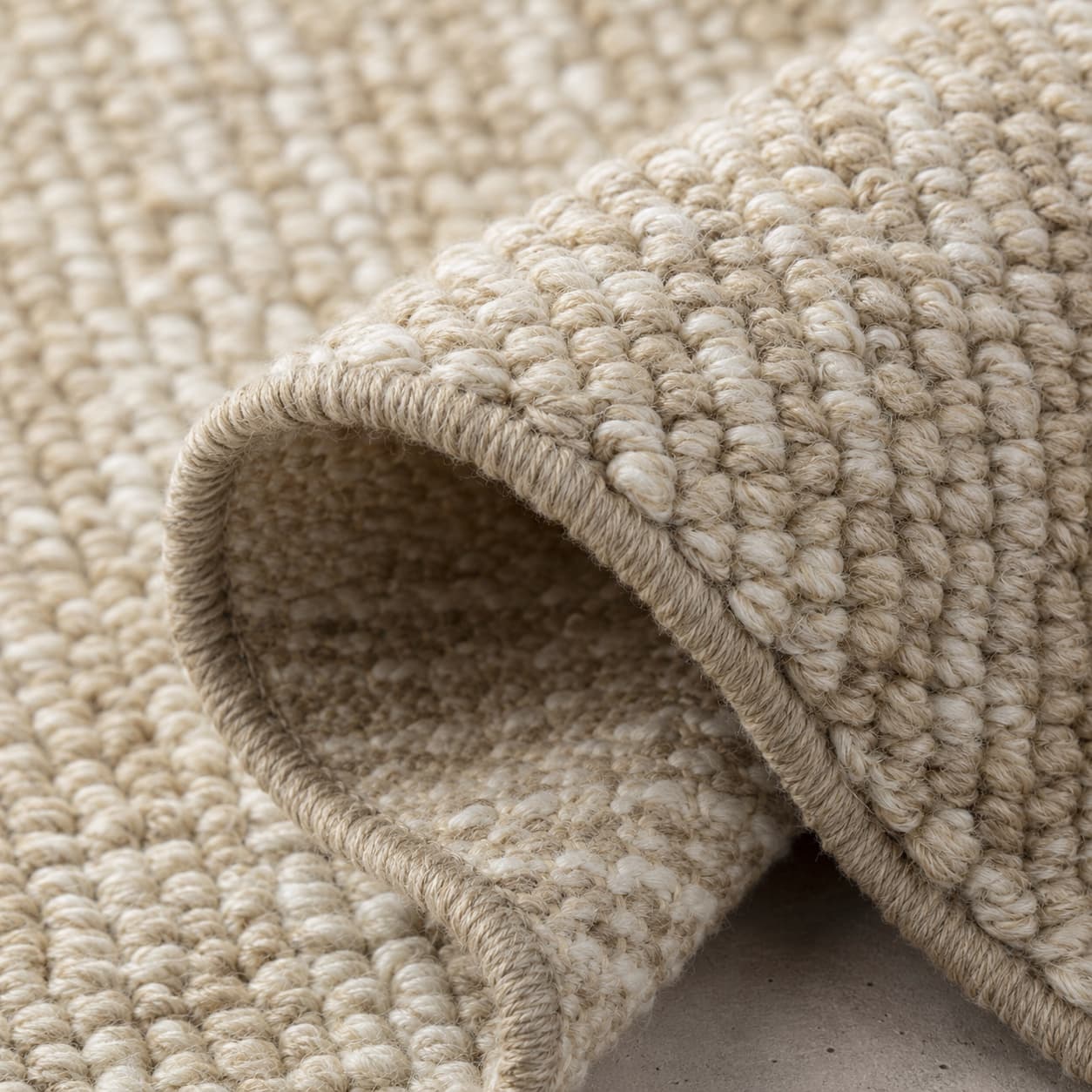Macro photograph of dense washable low-pile woven fibre in warm sand and chalk showing a resilient loop structure